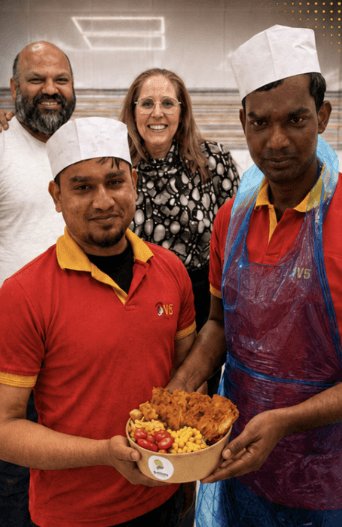 Partner kitchen team holding an e-vittles bowl.
